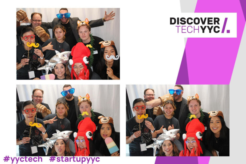 Group of attendees at DiscoverTech YYC event enjoying a photo booth, wearing fun props and costumes, showcasing creativity and engagement in a vibrant atmosphere.