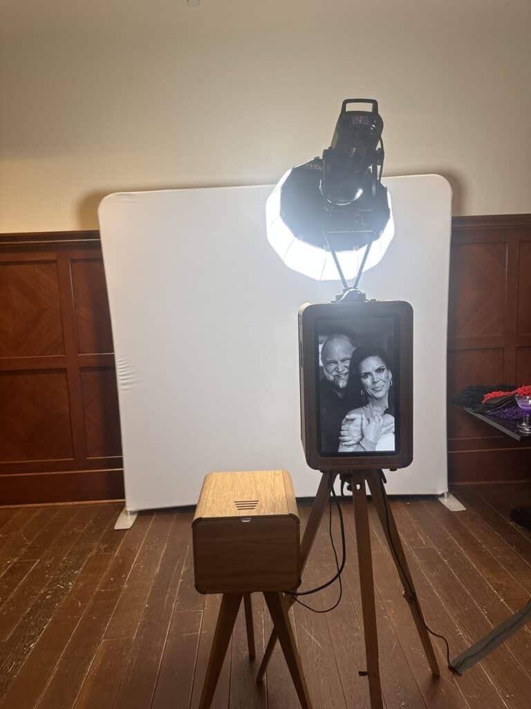 Open-air photo booth setup with professional lighting and custom print design for weddings.