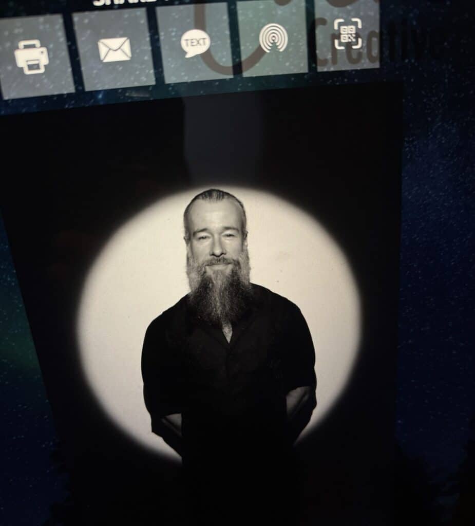 Bearded man in a black shirt posing confidently under cinematic spotlight, showcasing the refined visuals of the Spotlight Experience for event photography.