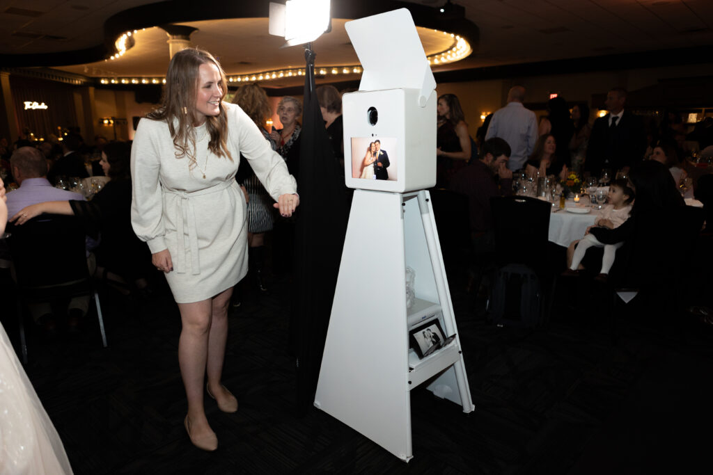 Woman interacting with a photo booth at a wedding