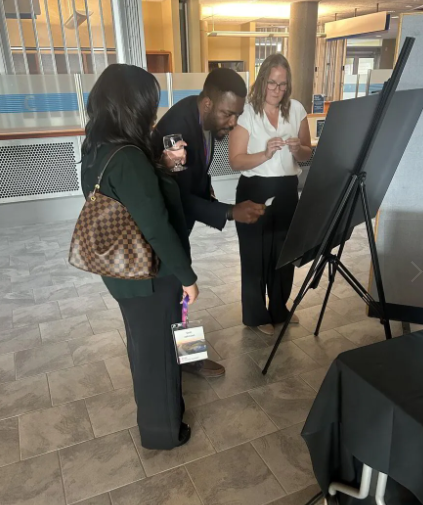Attendees engaging with the physical mosaic display at the ENMAX Leadership Summit, showcasing collaborative participation in the event at the University of Calgary.