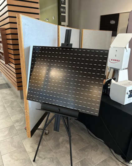 Digital and physical mosaic display on an easel at ENMAX Leadership Summit, showcasing guest interactions and engagement through a collaborative art project.