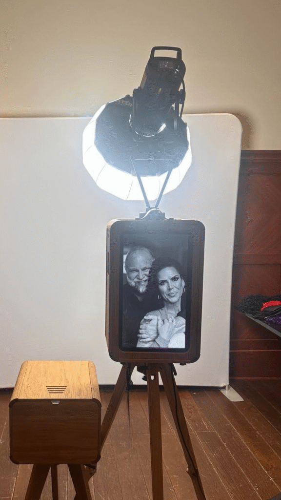 Eclipse photo booth setup with elegant lighting, featuring a couple's black-and-white portrait on the screen, capturing memorable moments at a wedding event in Thomsons Social Hub, Calgary.