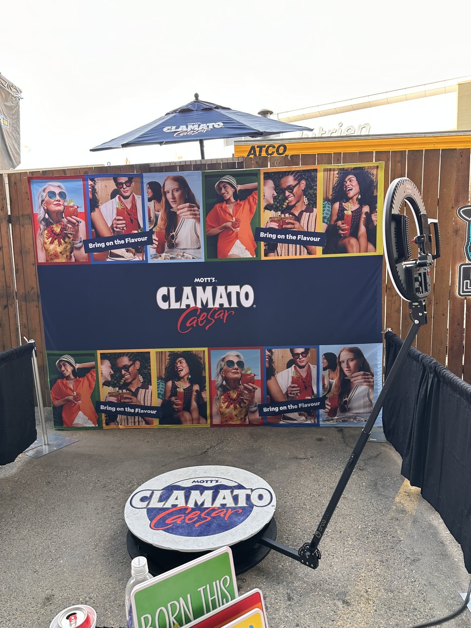 Western-themed photo booth setup featuring Mott's Clamato Caesar branding, vibrant backdrop with guests enjoying drinks, and a photo capture station for engaging Stampede celebrations.