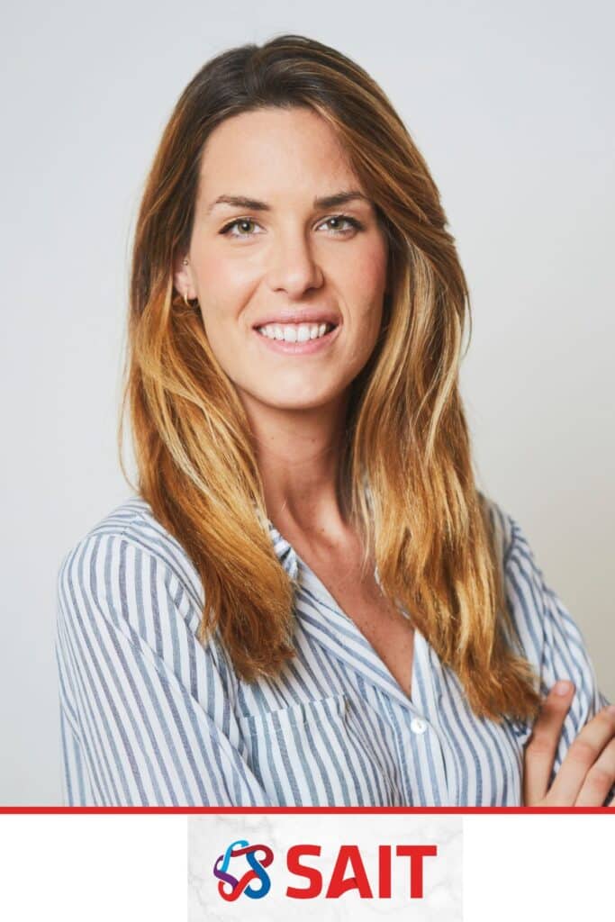 Professional headshot of a woman with long, wavy hair, smiling confidently in a striped shirt, featuring the SAIT logo at the bottom, showcasing quality portrait photography for corporate events.