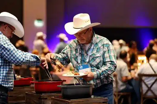 Cowboys serving food at a buffet in a lively event setting, highlighting experiential marketing and brand engagement in Calgary.