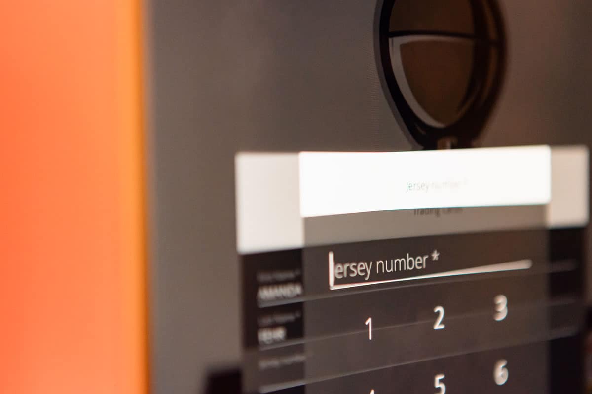 Input field displaying "Jersey number" with numeric keypad, part of a trading card activation experience at a sports event.