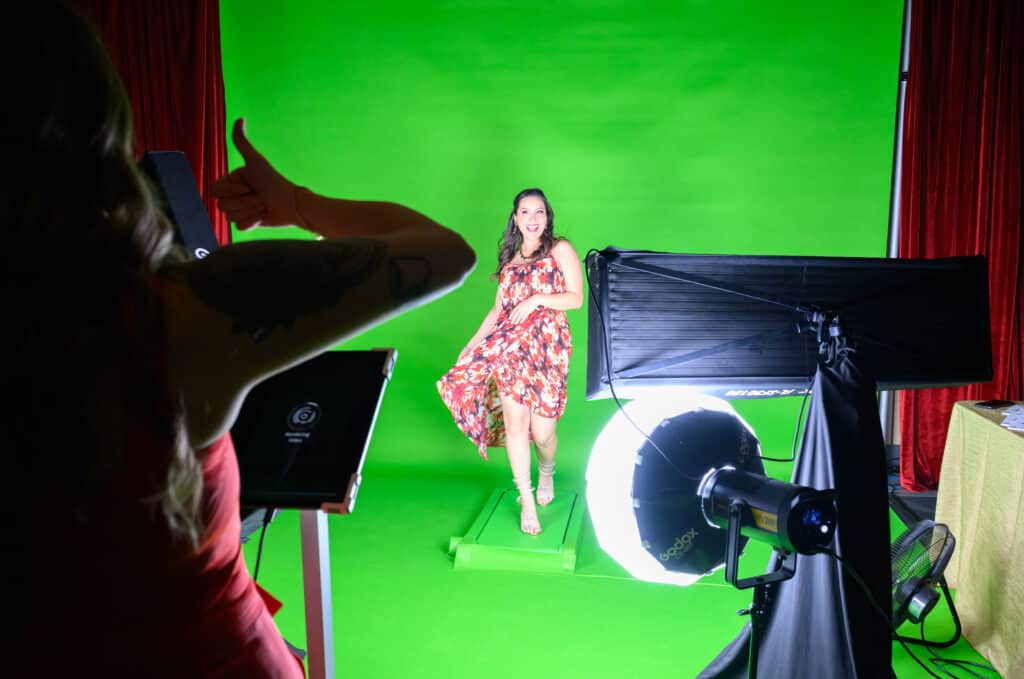 Woman being photographed at a gala in front of a green screen