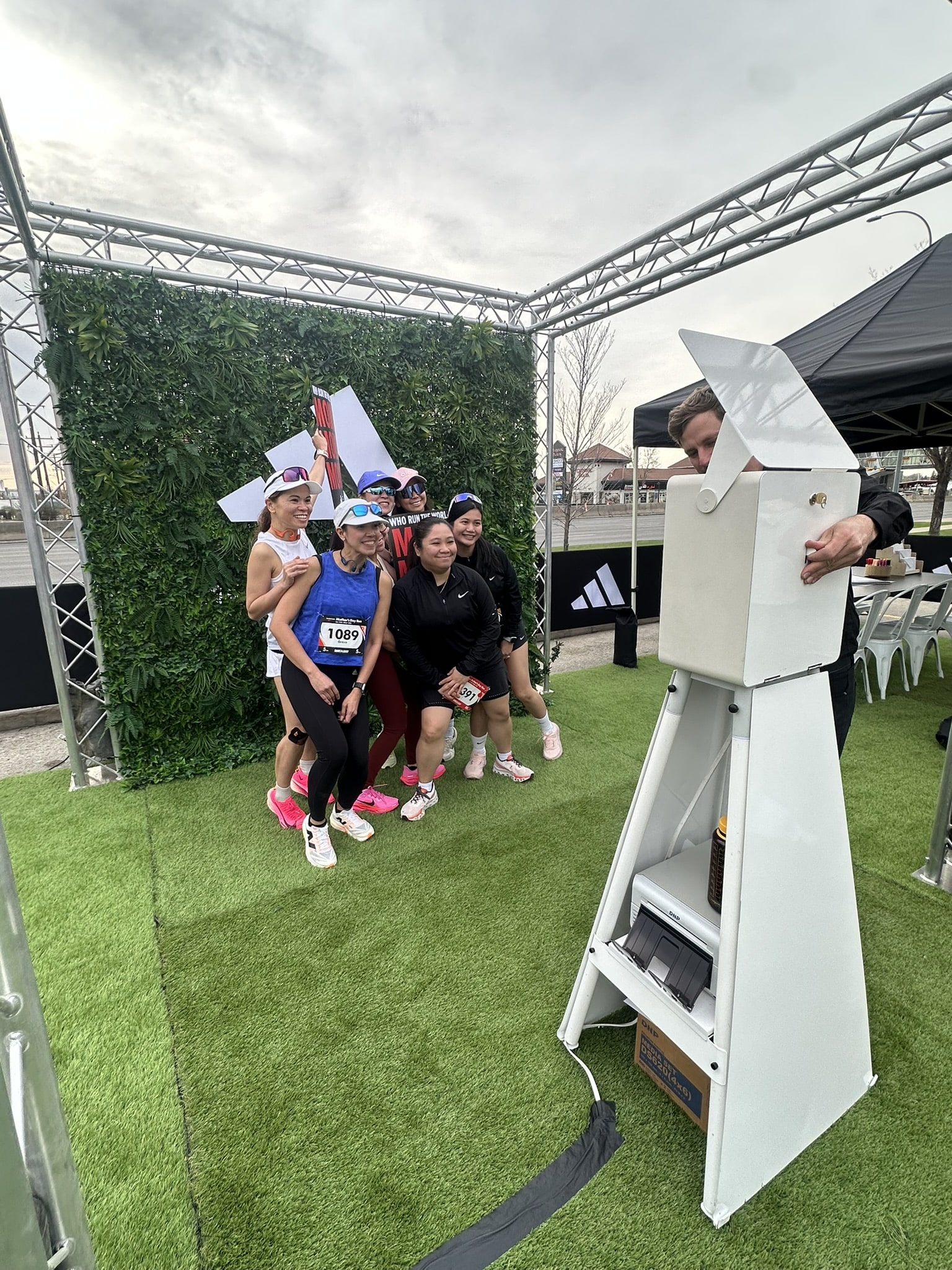 Branded photo booth activation at corporate event with attendees and staff, showcasing experiential marketing solutions