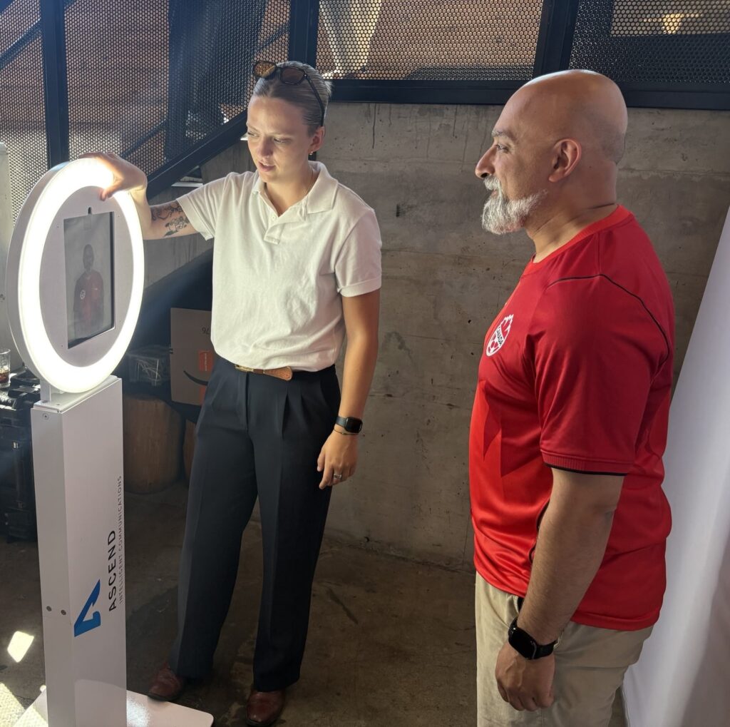 Attendees interacting with a Cosmo Photo Booth at a corporate event, illustrating photo privacy considerations.