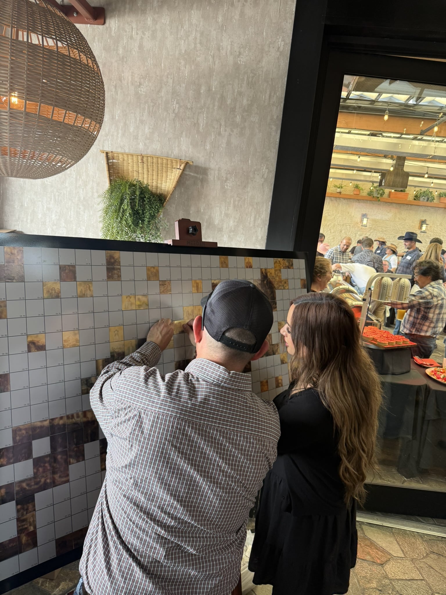 Veriforce Stampede celebration: guests placing mosaic tiles on collaborative artwork.